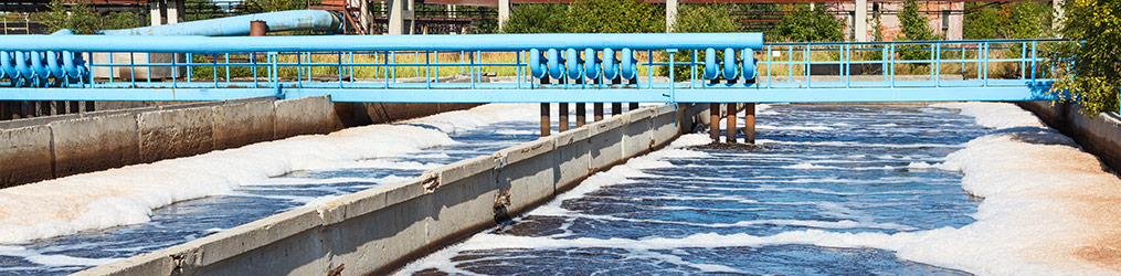 A blue catwalk with wastewater being treated underneath.